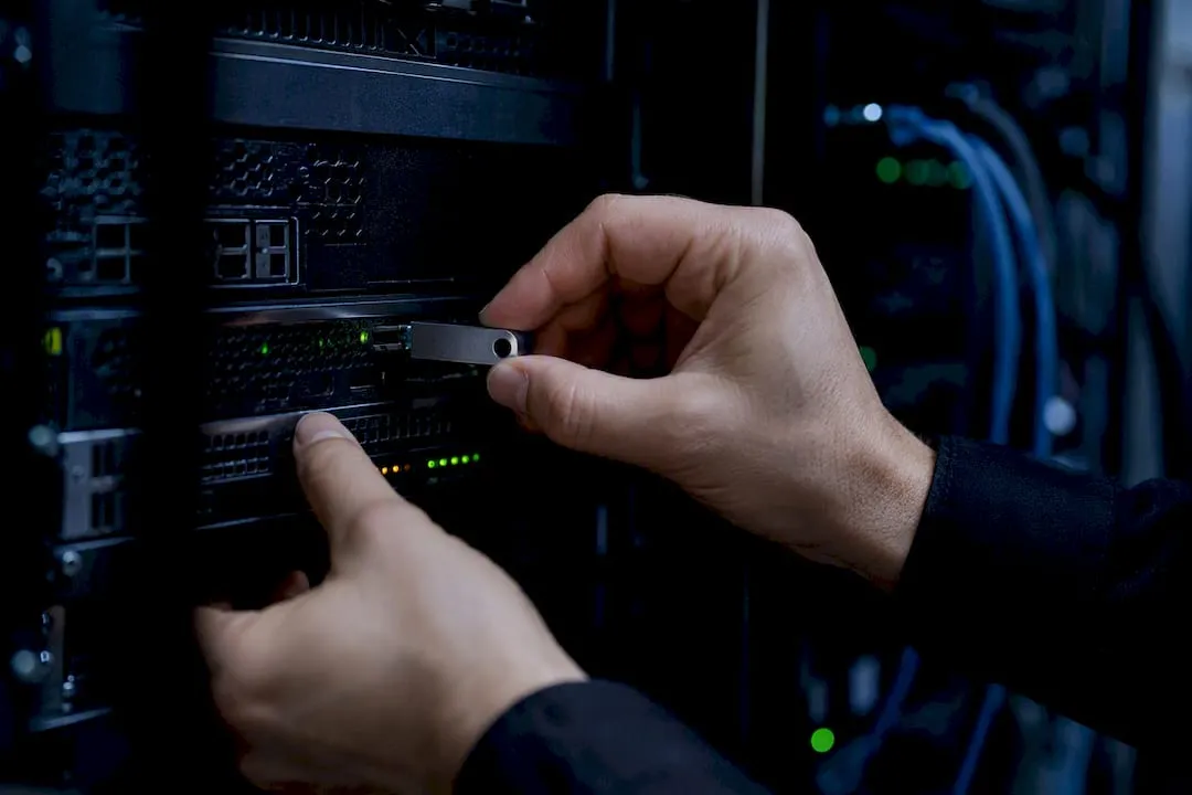 Hands installing tracking device in server rack